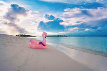 Beautiful Seascape At Sunset. Sandy Beach And Inflatable Pink Flamingo In Maldives.