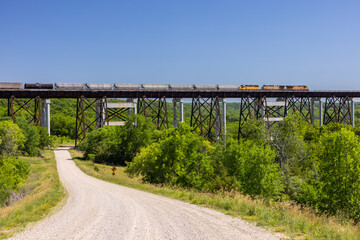 Freight Train Traveling Across High Trestle Bridge