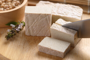 Fresh Tofu cutting by kitchen knife on wooden board, Food ingredient in Asian cuisine