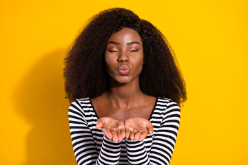 Poster - Photo portrait of curly girl in striped shirt sending air kiss with pouted lips isolated vibrant yellow color background