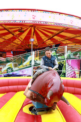 Kid riding on mechanical bull