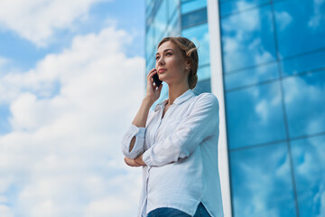 Businesswoman successful woman business person standing outdoor corporate building exterior. Pensive caucasian confidence professional business woman middle age