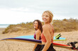 © merla - Beautiful young women going to surf in the sea.