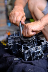 Wall Mural - A motorcycle mechanic is working on the engine gear.	