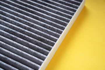 Wall Mural - Car cabin carbon air filter on a yellow background.