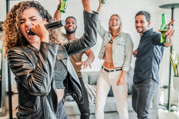 Wall Mural - Group of friends playing karaoke at home.