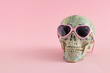 Wall Mural - Skull with glasses on pink background. Halloween creative fashion love concept. Copy space.