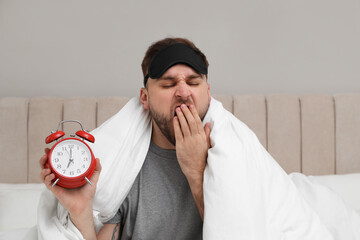 Canvas Print - Overslept man with alarm clock in bed. Being late concept