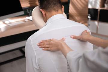 Sticker - Man receiving massage in modern chair indoors, closeup