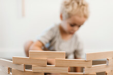 Young Boy Stacking Wooden Building Blocks On Top Of Each Other