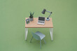 © Yaroslav Danylchenko/Stocksy - Papercraft table with laptop and lamp on green background