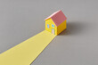 © Yaroslav Danylchenko/Stocksy - Papercraft yellow house on gray background