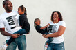 © Erin Brant/Stocksy - Happy Black parents carrying daughters