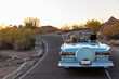 © Raymond Forbes Photography/Stocksy - Two Friends driving down road in blue convertible