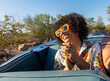 © Raymond Forbes Photography/Stocksy - African American Woman riding in car with cool sunglasses