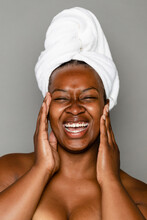 Laughing Woman Applying Skincare Products To Her Face