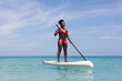 © Viktor Solomin/Stocksy - Focused woman standing on SUP board in sea