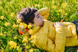 © ByLorena/Stocksy - Mixed race teenager resting in blooming field