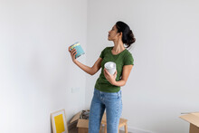 Woman Choosing The Color Of Paint At New Home