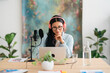 © Studio Marmellata/Stocksy - Smiling woman in headphones recording podcast in studio