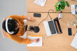 © Studio Marmellata/Stocksy - Asian woman recording podcast at table in open space studio
