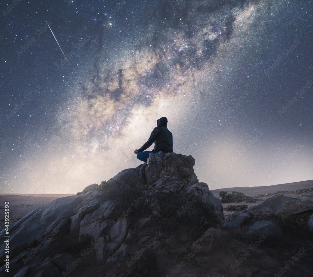 person meditating at night under the Milky Way - obrazy, fototapety, plakaty 