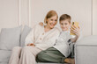 © Alina Hvostikova/Stocksy - Content mother and son taking self shot on smartphone