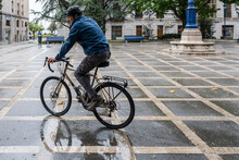 Man Cycles In The Rain