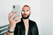 © Eloisa Ramos/Stocksy - Modern man with concealer patches doing a selfie
