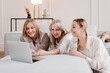 © Alina Hvostikova/Stocksy - Cheerful women watching movie together on laptop