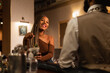 © Kike Arnaiz/Stocksy - Black woman flirting with man in bar
