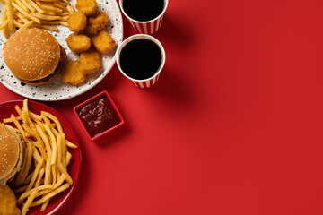 different fast food on red background, flat lay. space for text