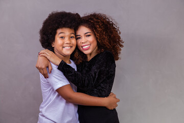 Wall Mural - Portrait of young African American mother with toddler son. Grey background. Brazilian family.