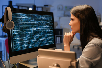 female programmer working with computer in office at night