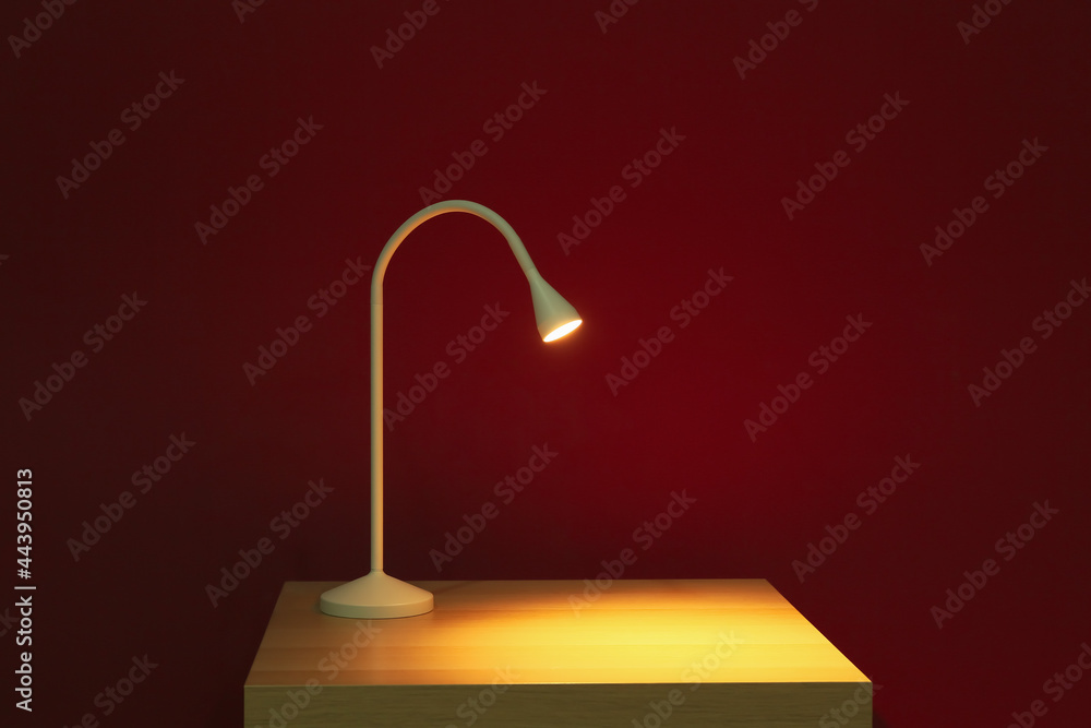 Glowing lamp on table in dark room