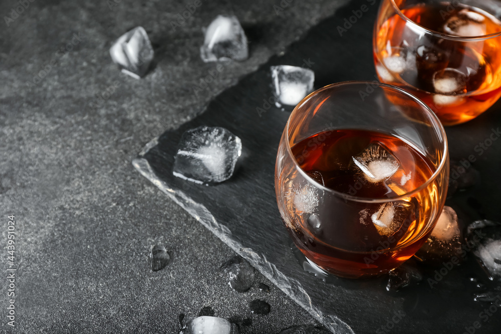 Glasses of cold whiskey on dark background