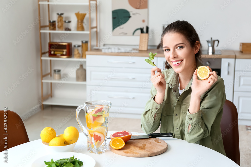 Young woman making fresh lemonade at home