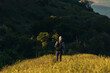 © Shopping King Louie - Male traveler, with a backpack, looks at the amazing mountains and forest, man on a country walk, hiking in the countryside, travel concept