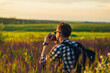 © Shopping King Louie - Young male tourist, in sunglasses, with a camera, in nature, spending time in a hike, on the field