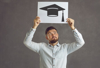 Hmm, is tassel worth hassle. Thoughtful pensive student with graduate cap paper image hesitating whether he needs to get degree and evaluating his chances to enter university. Higher education concept