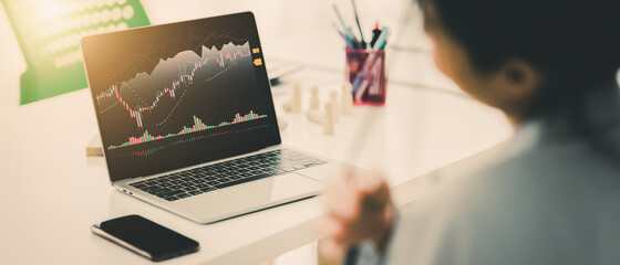 Young money businessman sitting staring at a computer screen displaying a cryptocurrency featuring stock tickers or graphs. Stock trading platform concept. professional financial advisor.