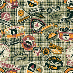 Wall Mural - Cute mountain camp and wildlife adventure badges patchwork with grunge tartan plaid background vector seamless pattern 