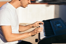 Side View Of A Man Playing Music Keyboard On A Rooftop