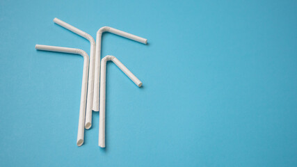 Wall Mural - Biodegradable eco friendly white paper drinking straw on blue background