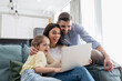 © LIGHTFIELD STUDIOS - excited couple with daughter watching movie on laptop at home