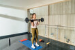 © Mattia/Stocksy - Woman Exercising at home with Weights