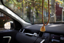 Buddhist prayer beads hung from rear mirror inside car