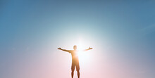 People Happiness, Hope, Light , And Power Concept. Man With Arms Raised To The Colorful Sky 