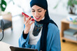 © Studio Marmellata/Stocksy - Positive Arab woman recording voice message in studio