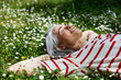 © BONNINSTUDIO/Stocksy - Delighted middle aged female lying on grass